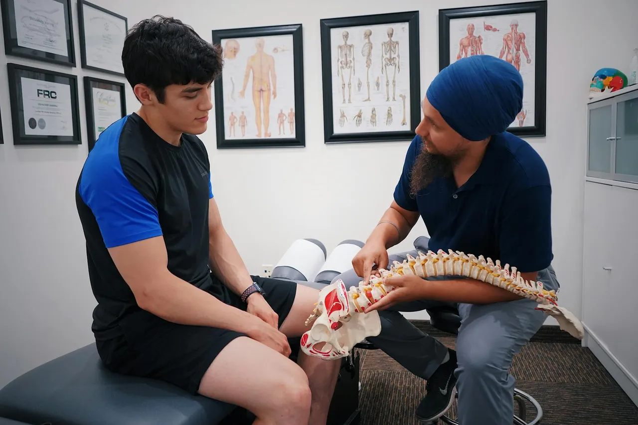 A healthcare professional demonstrating spinal cord stimulation technology to a patient, showing the device and its placement on a diagram.